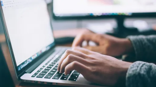 person is typing with laptop